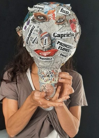 Escultura de una cabeza con varias capas de papeles, recortes...